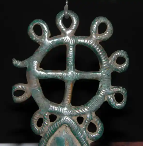 A cross in a solar disc on top of an eye-like symbol